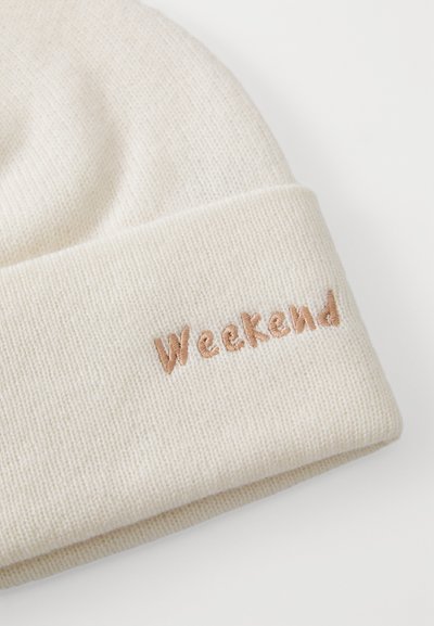 Kreemine kootud müts, millel on volditud serv, millel on kergepruun värviga broderitud tekst "Weekend". Pehme tekstuur ja lihtne disain.