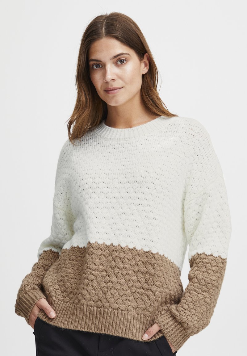 Strickpullover mit einem strukturierten oberen Abschnitt in Creme und einem unteren Abschnitt mit braunem Wabenmuster; runder Halsausschnitt und gerippte Bündchen.