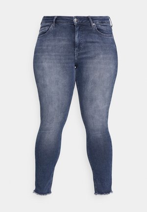 Jeans ajustados en denim de lavado oscuro. Presentan una cintura alta, cinco bolsillos y dobladillos deshilachados. El material muestra un ligero desgaste para un efecto usado.