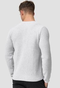 Light gray long-sleeve sweater with a textured knit, round neckline, and fitted sleeves, featuring a straight hem and minimal seams.