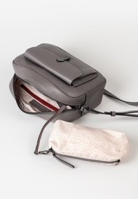 Graue Leder-Umhängetasche mit Klappenverschluss, ausgestattet mit einem gefütterten Innenraum und einem kleinen, gemusterten Beutel aus leichtem Stoff daneben.