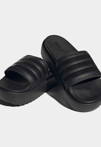 Sorte sandleder med en tyk gummisål, tekstureret fodseng og tre vandrette striber på remmen for en sikker pasform.