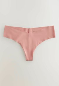 Culotte string rose pâle sans coutures avec une ceinture en forme de V et des bords plats, présentée sur un fond blanc.