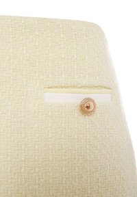 Tissu de couleur crème avec un tissage texturé, comportant une petite poche horizontale avec une bordure crème et un bouton décoratif en or rose.