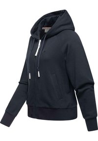 Mornarica majica sa patentnim zatvaračem i kapuljačom s čipkom, kengurskim džepovima i rebrastim manžetama. Izrađena od mekanog materijala, sa suptilnim detaljem logotipa.