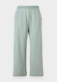 Hellgrüne Sweatpants mit einem elastischen Bund, weitem Bein und einer weichen Textur. Auf der Seite befindet sich ein kleines Logo.