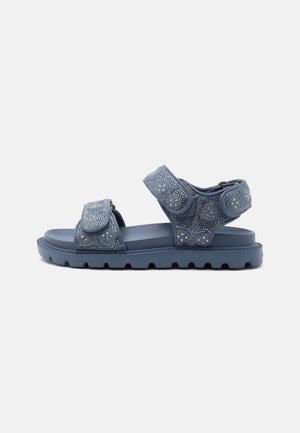 Une sandale bleue unique avec deux brides réglables présentant un motif texturé à pois et une semelle épaisse crantée sur un fond uni.
