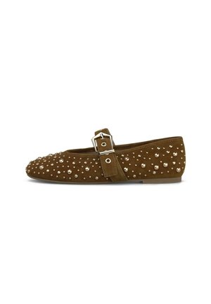 Zapato plano de gamuza marrón con tachuelas plateadas y una correa con hebilla en la parte superior, mostrado de lado sobre un fondo blanco.