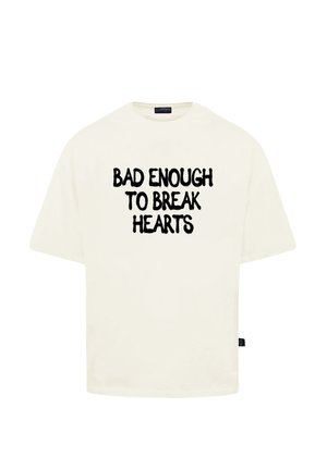 Cremfarbendes T-Shirt mit kurzen Ärmeln in lockerer Passform, mit fettem schwarzen Text auf der Vorder- und Rückseite, der "BAD ENOUGH TO BREAK HEARTS" lautet.