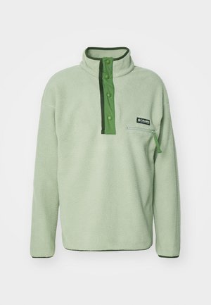 Pullover in pile verde chiaro con colletto alto, chiusura a bottoni a pressione e tasca sul petto con zip. Presenta dettagli verde scuro e un tessuto testurizzato.