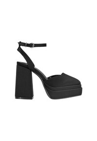 Sandalias de plataforma negras con un tacón cuadrado y contundente, correa ajustable en el tobillo, parte superior de tela suave y diseño de punta abierta.