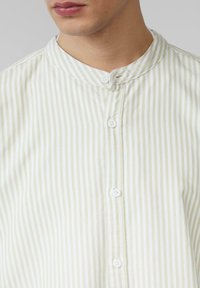 Overhemd met knoopsluiting in lichtgroen en witte strepen, met een bandkraag en vijf witte knopen aan de voorkant, gemaakt van een zachte stof.