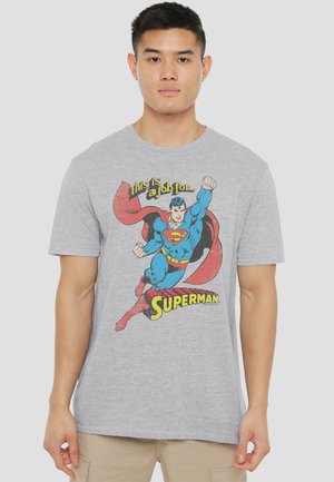 Young man wearing a gray t-shirt featuring flying Superman with text "This is a job for Superman" on front.