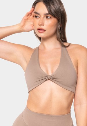 Smešani bikini top sa halter vratom i dubokim V izrezom. Čvor na sredini i glatka, rastezljiva tkanina.