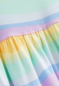 Robe en tissu côtelé présentant des rayures horizontales dans des pastels doux : vert menthe, lavande, pêche, jaune et blanc. Détail de jupe froncée.