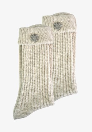 Gestrickte Wollsocken mit gerippter Textur in Creme, mit umgeschlagenem Bündchen und silberner Blumenakzent an der Seite.