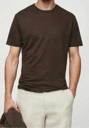 Brun kortærmet T-shirt lavet af blødt stof, med rund hals og afslappet pasform, parret med lysfarvede linnedbukser.