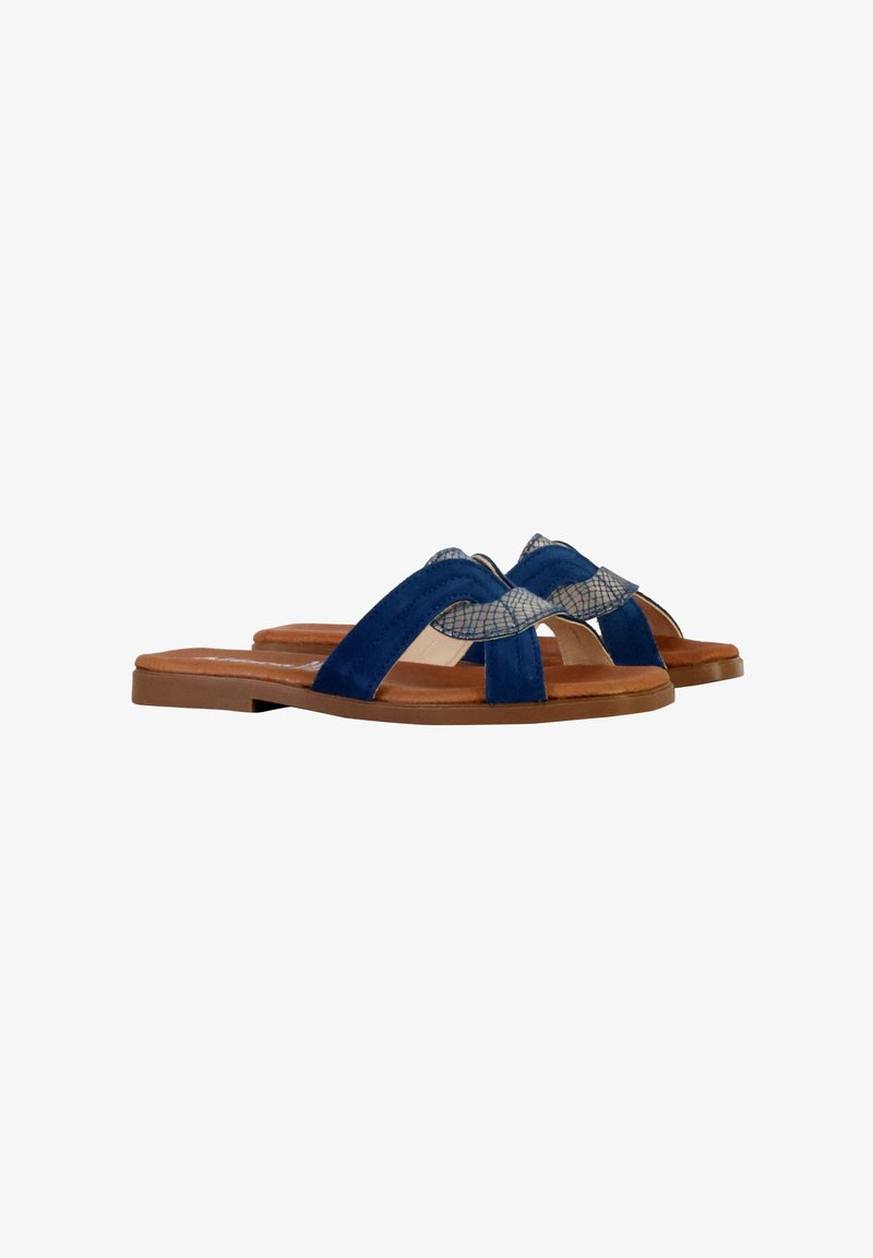 Sandales à glissière en suedine bleue avec un accent beige texturé sur le dessus. Semelle plate et design à bout ouvert pour un usage polyvalent.