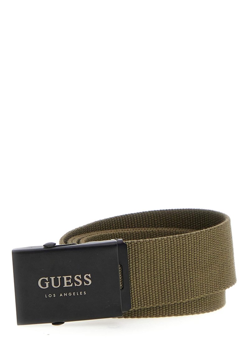 Zeleni tkanjeni pojas s pravokutnom crnom metalnom kopčom na kojoj je ispisano ime brenda "GUESS LOS ANGELES" srebrnim slovima.
