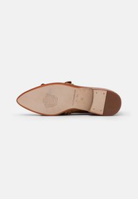 Semelle de chaussure en cuir marron à texture lisse, forme à bout pointu, marquage subtil de la marque et détail décoratif près du talon. Taille indiquée comme 37.