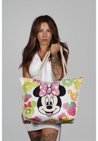 Bolsa de tela con un gran diseño de Minnie Mouse, patrones de frutas coloridas y asas de cuerda gruesa. Predominantemente blanca con acentos en rosa.