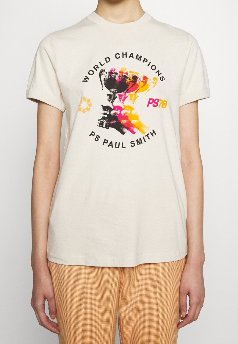 Camiseta de algodón color crema con un gráfico colorido de un trofeo y manos, con el texto "CAMPEONES DEL MUNDO" y "PS PAUL SMITH." Mangas cortas.