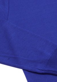 Țesătură tricotată de culoare albastru regal, cu o textură netedă, având o finisare fără cusături și manșete elasticizate. Material ușor și respirabil.