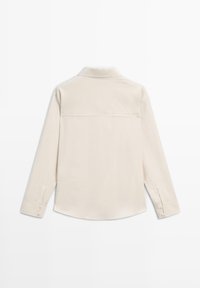 Beige overhemd met lange mouwen en een kraag, rugnaad, knoopmanchetten en een gebogen zoom. Gemaakt van een soepele, lichte stof.