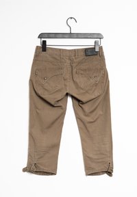 Hnědé cargo kalhoty mají dvě zadní kapsy s klopami, detail na knoflík a nastavitelné manžety se zacvakávacími uzávěry. Tkanina vypadá strukturovaně.