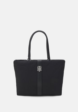 Czarna prostokątna torba na ramię z dwoma uchwytami, pionowym teksturowanym paskiem i metalicznym logo "TH" umieszczonym na środku przedniej strony.