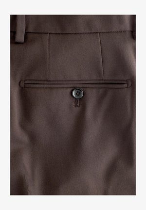 Brune stofbukser har en baglomme med en syet kant og en enkelt sort knaplukning. Teksturen er glat med en subtil glans.