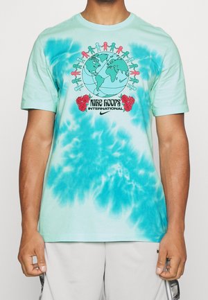 Turkusowa koszulka tie-dye z globusem, czerwonymi i zielonkawymi papierowymi lalkami wokół, czerwonymi różami i napisem „Nike Hoops International”.