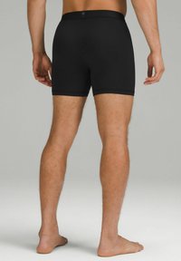 Mustad puuvillased bokserid mustas värvuses, sileda tekstuuriga, keskmise reie pikkusega ja logo, mis on diskreetselt paigutatud vöökoha peale.