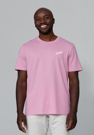 Light pink cotton t-shirt with a round neckline, short sleeves, and white "GO GREEN!" text on the left chest area. Smooth texture.