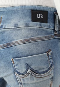 Light blue denim jeans with prominent stitching, leather LTB label on the back, and a small pocket featuring a wavy design.