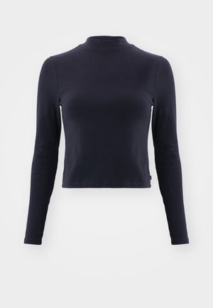 Crop top à manches longues en marine avec un col montant. Fabriqué en tissu doux, il possède une coupe ajustée, des coutures discrètes et aucun motif ou accent visible.
