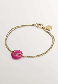 Pulsera de cadena de oro con un encanto circular de resina rosa, texturizado con un acabado brillante, asegurado con un cierre de langosta.