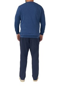 Blauwe sweatshirt met lange mouwen, ronde hals en geribbelde boorden, gecombineerd met marineblauwe broek. Een gladde textuur en een fitted ontwerp.