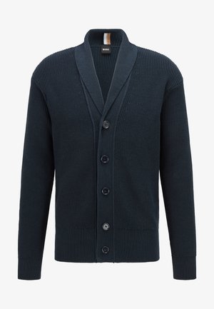 Marineblauer gestrickter Cardigan mit Schalkragen, fünf Knöpfen vorne, gerippten Bündchen und Saum sowie einem kleinen schwarzen Etikett am Kragen.