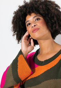 Maglione a strisce colorate con tonalità di verde, rosa, arancione e beige. Realizzato in materiale a maglia con maniche larghe e scollo rotondo.
