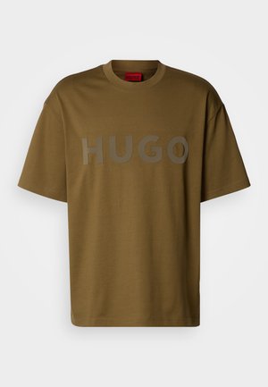 Oliivroheline puuvillane T-särk ümarate kaelustega ja lühikeste varrukatega, millel on ees suur hall "HUGO" logo.