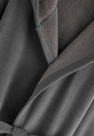 Šedý plášť s ribbeným povrchom, mäkkým plyšovým interiérom a pásikom na viazanie. Prekrývajúci sa golier zvyšuje teplo a pohodlie.