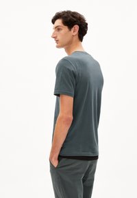 Korte mouwen, ronde hals t-shirt in gedempt teal, gemaakt van zachte katoen. Heeft een relaxte pasvorm en subtiele stiksels aan de zoom.