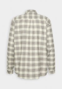 Koszula na guziki z długim rękawem w beżowo-szary wzór w kratę, widoczna od tyłu na jednolitym tle.