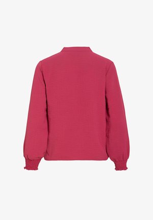 Garām piedurknēm sarkana blūze ar teksturētu audumu, savilktām elastīgām aprocēm un nelielu apkakli, redzama no muguras uz baltas virsmas.