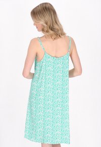 Rochie fără mâneci, verde mentă, cu un model floral, având bretele delicate tip spaghetti și un design fluid care se termină sub genunchi.