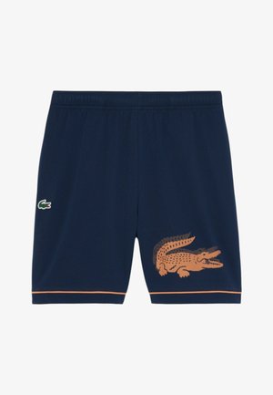 Pantaloncini blu navy con fascia elastica in vita, piccolo logo di coccodrillo verde sul lato sinistro, grande grafica di coccodrillo arancione sulla gamba destra e rifinitura arancione all'orlo.