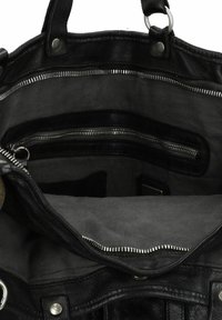 Zwarte leren handtas met een grijze stoffen binnenkant. Voorzien van ritszakken, metalen hardware en een gestructureerde buitenkant. Ruimtelijk ontwerp.