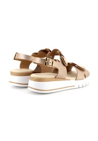 Sandal in beige chiaro con suola bianca spessa, cintura regolabile, decorazioni floreali e superficie morbida e liscia.