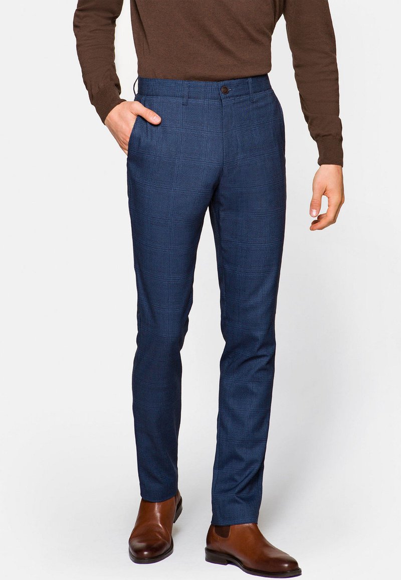 Granatowe, w kratę spodnie wykonane z teksturowanej tkaniny, charakteryzujące się dopasowanym krojem, bocznymi kieszeniami oraz pojedynczym zapięciem na guzik w talii.